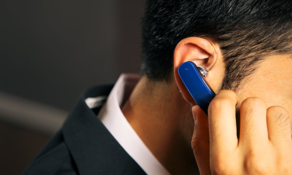 man wearing Bluetooth phone headset