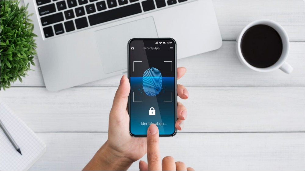 Person tapping a biometric identification app on a smartphone.