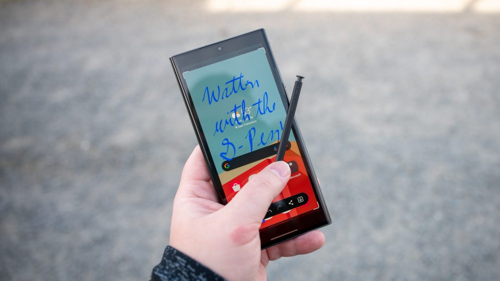 Person holding the Samsung Galaxy S23 Ultra and its S Pen with a hand-written note